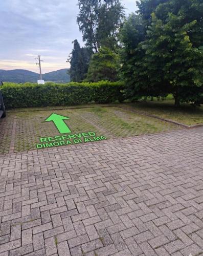 a green arrow on a brick walkway in a park at La Dimora di Alma in Clivio