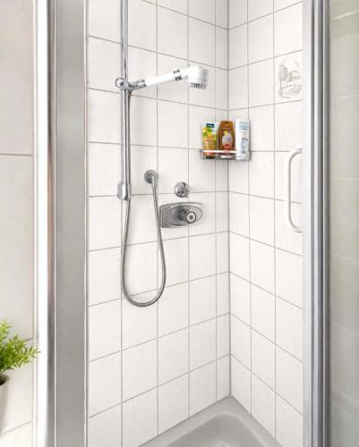 a shower in a white tiled bathroom at Sternlicht Rachida in Albstadt