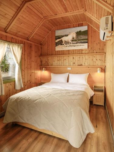 a bedroom with a large bed in a wooden room at ISSA Village in Turda