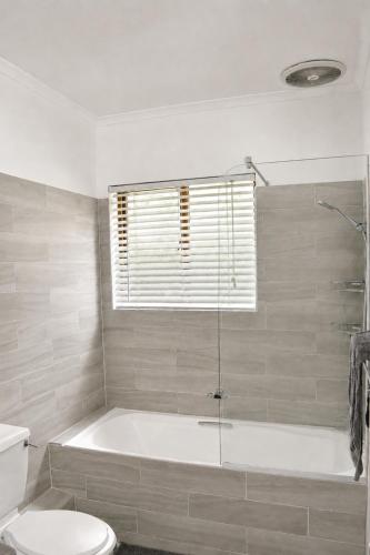 a white bathroom with a tub and a toilet at 26 on Greenway in White River