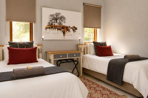 a bedroom with two beds and a painting on the wall at 26 on Greenway in White River