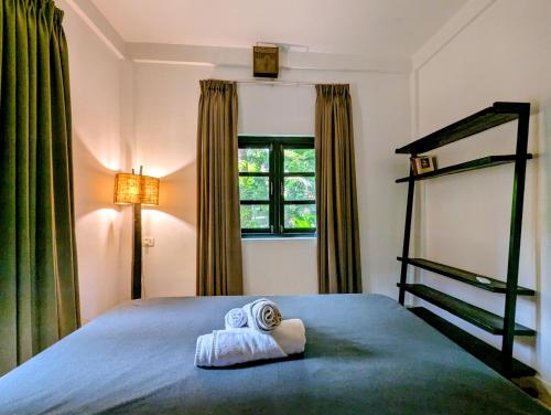ein Schlafzimmer mit einem Bett, auf dem zwei Handtücher liegen in der Unterkunft The Double V Experience in Arambol