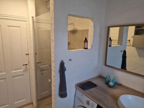 ein Badezimmer mit Waschbecken und Spiegel in der Unterkunft Strandhuset in Agger