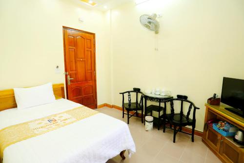 a bedroom with a bed and a table and a tv at Kother in Ho Chi Minh City