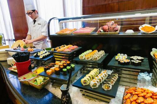 a chef standing in front of a buffet of food at Kother in Ho Chi Minh City