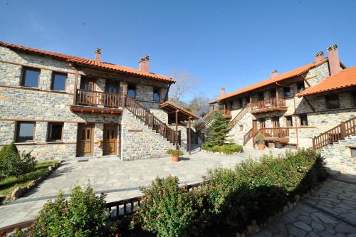 a large stone building with a patio and stairs at Enastron in Palaios Agios Athanasios