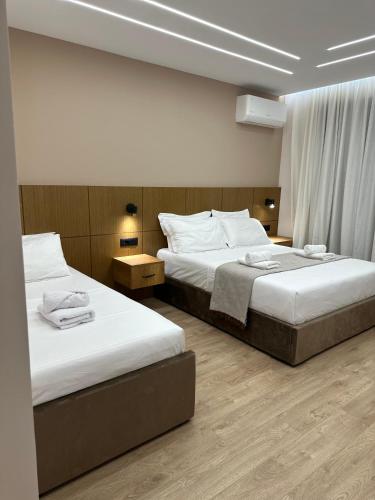two beds in a hotel room with two beds sidx sidx sidx at Vila Zhiti in Durrës