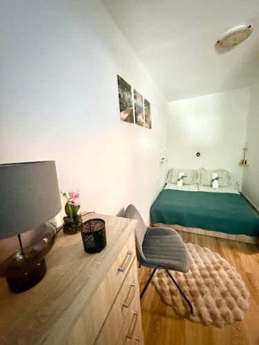 a bedroom with a bed and a desk with a chair at Thermal Oazis Apartman in Mosonmagyaróvár