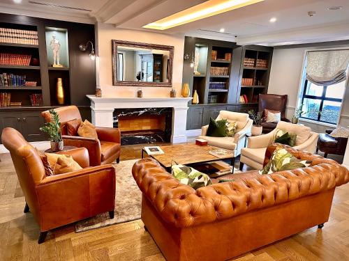 a living room with leather furniture and a fireplace at The Weinberg Windhoek in Windhoek