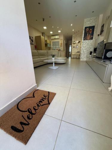 a living room with a welcome mat on the floor at S'Agapo Maisonette St' Julians in St. Julianʼs