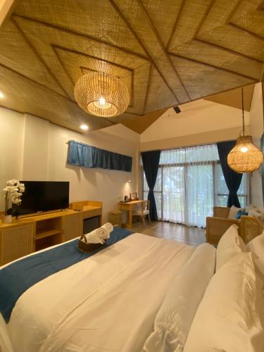 a bedroom with a large bed and a tv at Island Garden Beach Resort in Samal