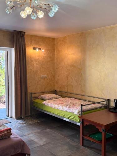 a bedroom with a bed and a table at Lindaga in Ragaciems