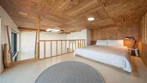 a bedroom with a bed in a room with wooden ceilings at Capella Oceanview Spa Resort – Goseong in Goseong