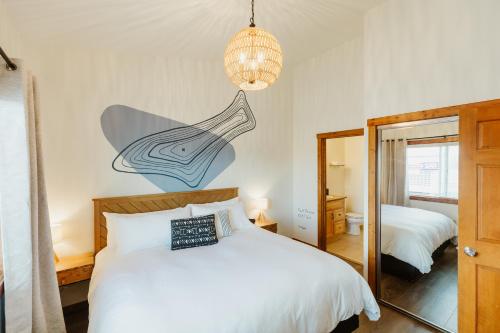 a bedroom with a white bed and a mirror at Mt Stimson Suite Work-From-Anywhere-Ready in Kalispell