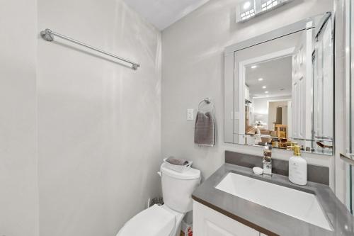 a bathroom with a sink and a toilet and a mirror at The Boxwood Executive Suite in Markham