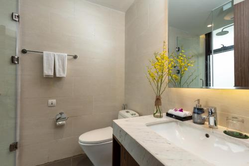 a bathroom with a sink and a toilet and a mirror at DIC Star Villas Vinh Phuc in Vị Trù