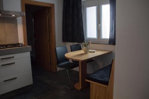 a small kitchen with a wooden table and a window at Ferienwohnung Götzis in Götzis