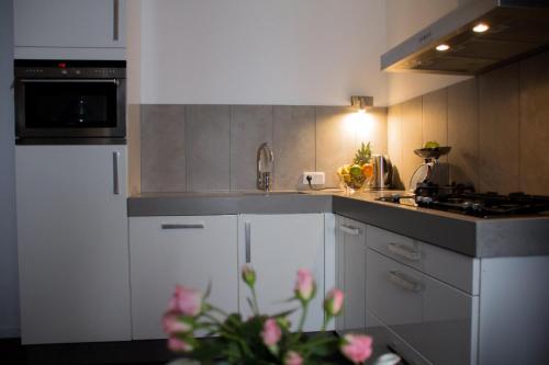 a kitchen with white cabinets and a stove top oven at Ferienwohnung Götzis in Götzis