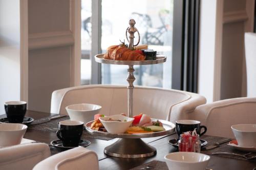 a table with a plate of food on a table at The Weinberg Windhoek in Windhoek