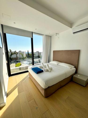 ein Schlafzimmer mit einem großen Bett und einem großen Fenster in der Unterkunft Sunset Park Villas in Paphos City