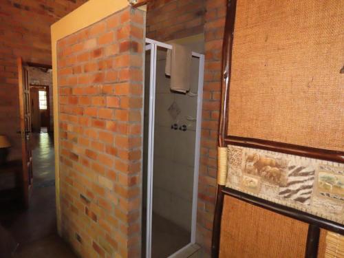 a walk in shower in a brick wall at Bush and Gables in Marloth Park