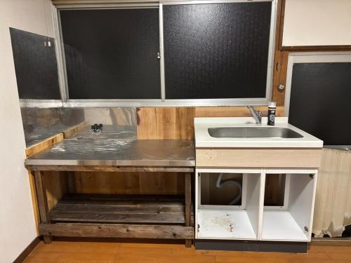 a kitchen with a sink and a counter at Aoi-Yane Traditional Japanese House in Kumano Kodo Nakahechi in Tanabe