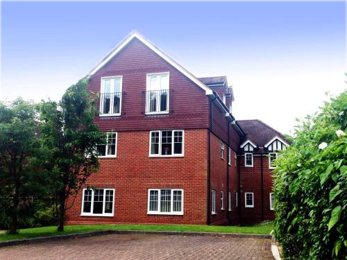 a large red brick building with white windows at Basingstoke Apartments - St Raphael House, City Centre Charming Apartments in Basingstoke