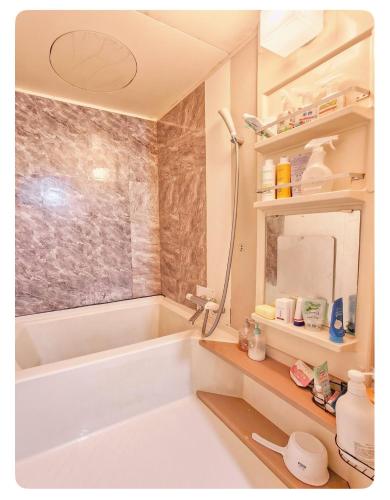 a bathroom with a bath tub and a sink at NEXTRAVELER iNN in Osaka