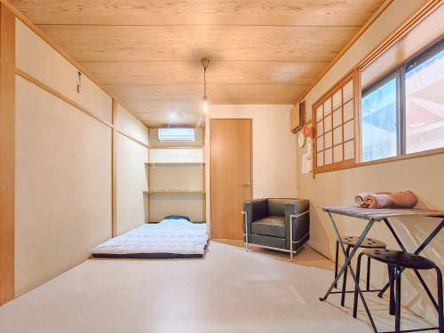 a room with a bed and a desk and a chair at NEXTRAVELER iNN in Osaka