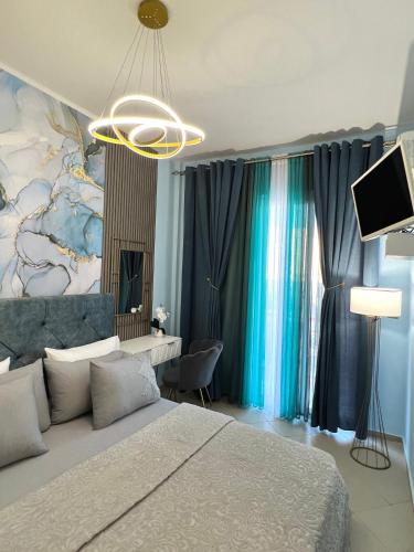 a bedroom with a bed and a tv and curtains at Bella Vista in Bali