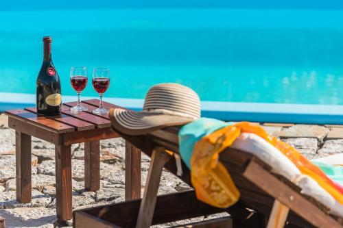 a table with two glasses of wine and a hat at Maripaul Family Villa in Lartos