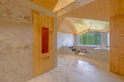 an open door in a room with a stone wall at Sterling Ameris Kasauli in Kasauli