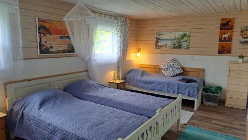 a bedroom with two beds and a window at Kapteni suvekodu in Laulasmaa