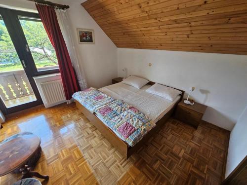 a bedroom with a bed and a wooden ceiling at Bohinjski kot in Bohinj