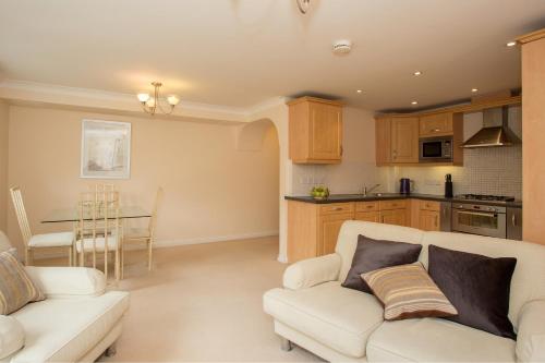 a living room with a couch and a kitchen at Basingstoke Apartments - Westlands House, City Centre, Home-From-Home in Basingstoke