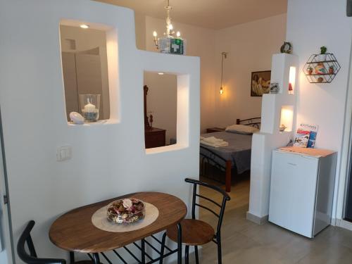 a room with a table and chairs and a room with a bed at Gorgona in Loutra