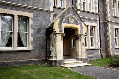 a brick building with a door with a clock on it at Basingstoke Apartments - Sherborne House, City Centre Victorian Apartments in Basingstoke