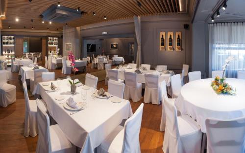 a dining room with white tables and white chairs at Hotel Artaza in Getxo