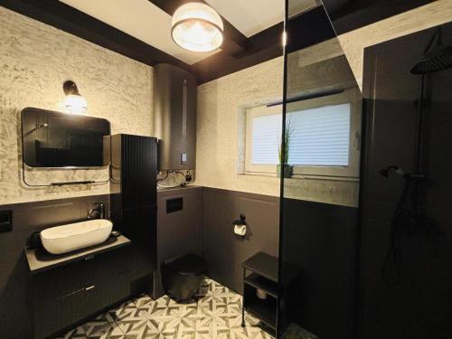 a bathroom with a shower and a sink and a mirror at RAJSKIE REZYDENCJE-Antresola Czarna,Antresola Biała in Bilcza