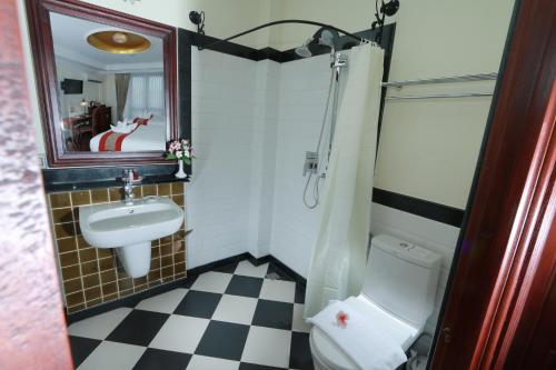 a bathroom with a sink and a toilet and a mirror at Phasouk Vien Chantra Hotel in Vientiane