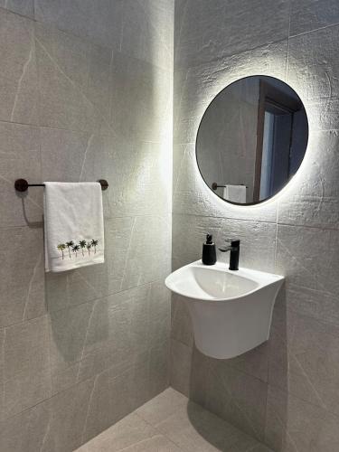a bathroom with a white sink and a mirror at Etlaala Chalet in Ibri