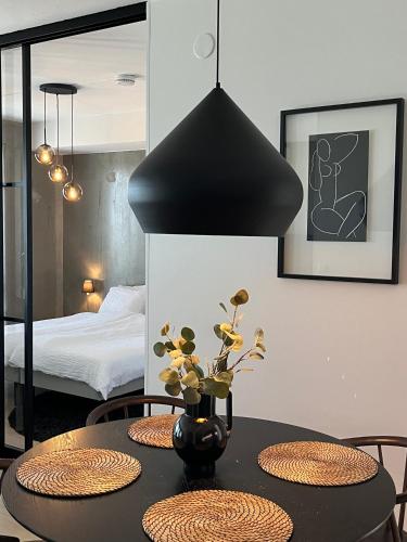 a dining room with a table with a vase with flowers at Tikka Apartments in Jyväskylä