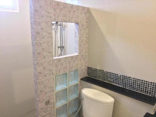 a bathroom with a toilet and a mirror at Suanrak Resort in Suphan Buri