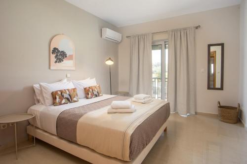 a bedroom with a large bed with towels on it at Elysian View Estate in Faliraki