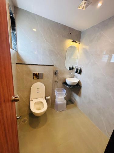 a bathroom with a toilet and a sink at Hotel Rajwada Nagpur in Nagpur