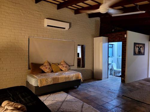 a bedroom with a bed in a brick wall at Cozy Cork Cottage - Sleeps 4 in Beacon Bay