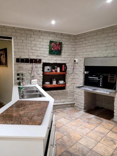 a kitchen with a sink and a microwave at Cozy Cork Cottage - Sleeps 4 in Beacon Bay