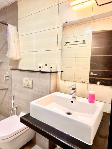 a bathroom with a white sink and a toilet at The Staying Co in Bangalore