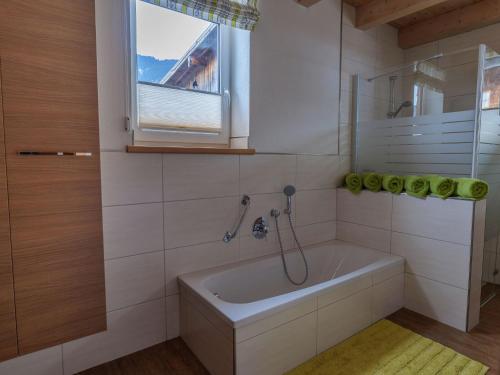 a bathroom with a bath tub and a window at Chalet near Passthurn Ski Area Kitzbühel in Mittersill