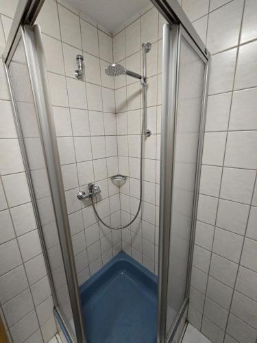 a shower with a blue tub in a bathroom at Monteur-Apartment Kusel City in Kusel